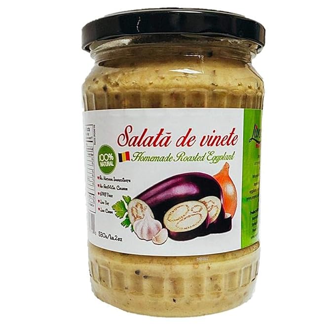 Glass jar of Salată de Vinete (Romanian-style eggplant salad spread) with a black lid. The label reads 'Homemade Roasted Eggplant' and displays illustrations of a purple eggplant, onion, garlic cloves, and parsley. The spread inside is light beige with visible seasoning specks. The label also highlights natural ingredients and a 550 g (19.2 oz) net weight