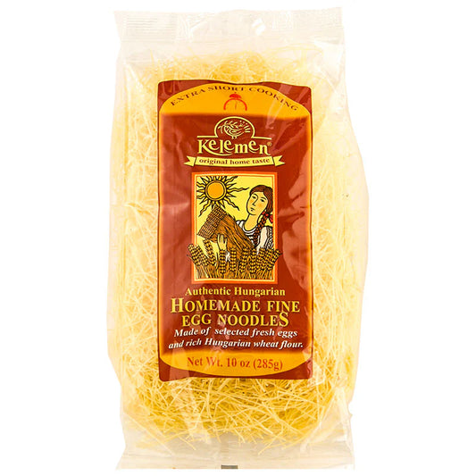 Clear plastic bag filled with very thin, pale yellow egg noodles. The front features a brown and gold Kelemen label with an illustration of a woman holding wheat beside a sun and wheat stalks. The package is labeled 'Authentic Hungarian Homemade Fine Egg Noodles' and notes that the noodles are made from fresh eggs and Hungarian wheat flour. Net weight is 10 oz (285 g)